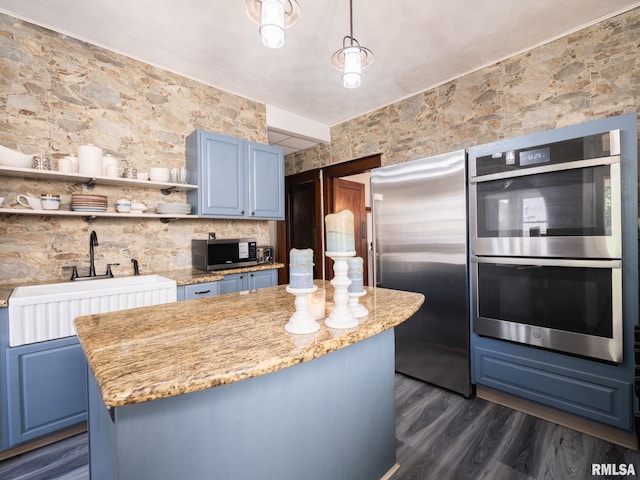405 Washington St, Pekin, IL 61554 - kitchen with stainless steel appliances, blue cabinetry, dark wood finished floors, and a kitchen island