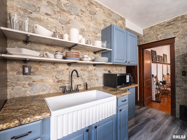 405 Washington St, Pekin, IL 61554 - kitchen featuring blue cabinets, open shelves, black microwave, dark wood-style flooring, and stone counters
