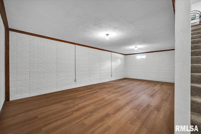 1208 S Adams Rd, Eureka, IL 61530 - below grade area with brick wall, ornamental molding, wood finished floors, stairs, and a textured ceiling