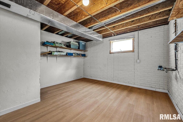1208 S Adams Rd, Eureka, IL 61530 - basement with wood finished floors and brick wall