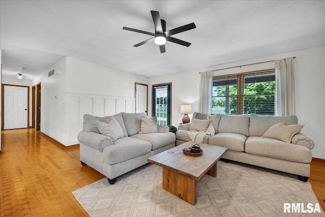 1208 S Adams Rd, Eureka, IL 61530 - living room with light wood-style floors, ceiling fan, and a textured ceiling