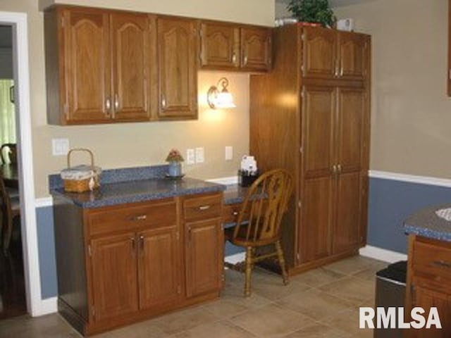 17215 N Mangold Rd, Edelstein, IL 61526 - kitchen featuring brown cabinets, dark countertops, and a desk