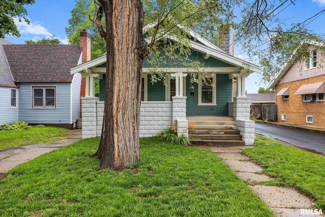 2017 W Laura Ave, West Peoria, IL 61604 - view of front of home featuring a chimney, a porch, a front yard, and roof with shingles