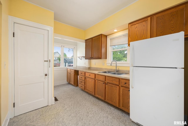 2017 W Laura Ave, West Peoria, IL 61604 - kitchen with freestanding refrigerator, brown cabinets, light countertops, and light flooring