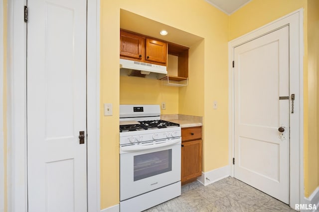 2017 W Laura Ave, West Peoria, IL 61604 - kitchen featuring white range with gas cooktop, under cabinet range hood, brown cabinets, light countertops, and light marble finish flooring