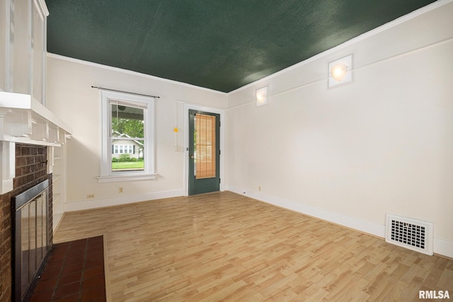 2017 W Laura Ave, West Peoria, IL 61604 - unfurnished living room featuring crown molding, wood finished floors, and a fireplace