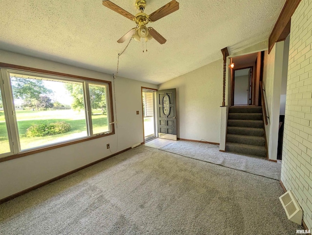 6646 Mason Rd, Manito, IL 61546 - unfurnished living room featuring a textured ceiling, carpet floors, stairs, a ceiling fan, and vaulted ceiling