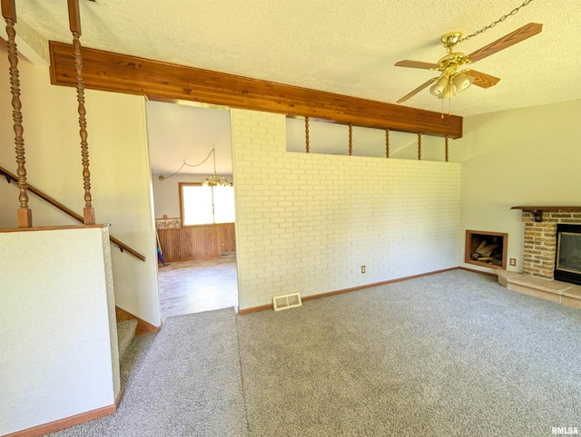 6646 Mason Rd, Manito, IL 61546 - unfurnished living room featuring a textured ceiling, carpet flooring, beamed ceiling, a ceiling fan, and a brick fireplace