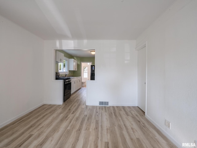 1108 Mechanic St, Pekin, IL 61554 - unfurnished living room featuring light wood finished floors and a sink