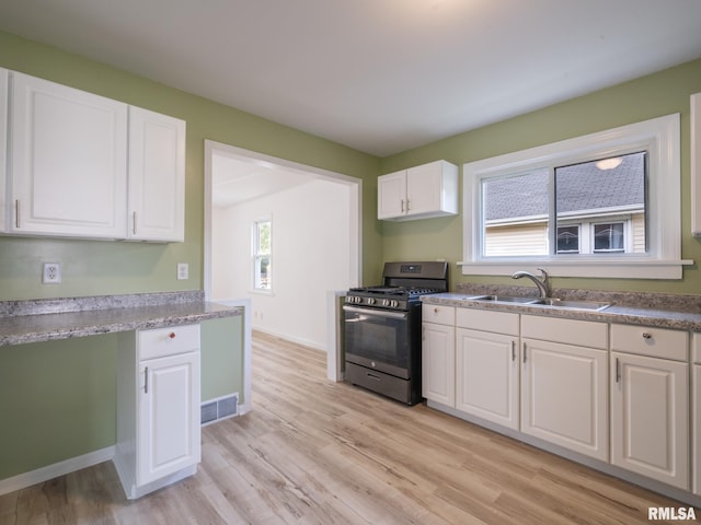 1108 Mechanic St, Pekin, IL 61554 - kitchen with stainless steel gas range oven, white cabinetry, and light wood-type flooring