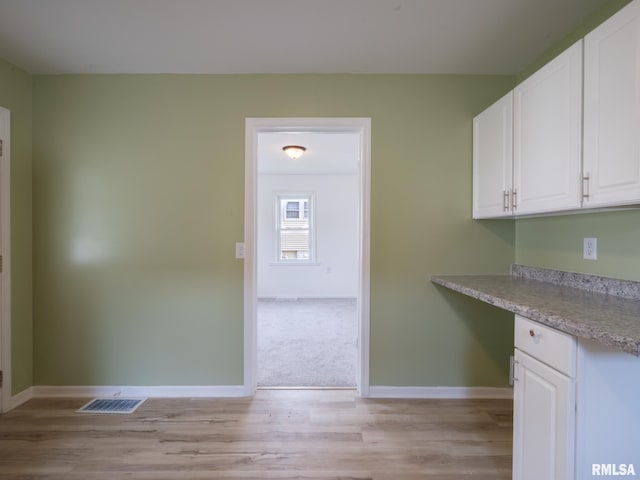 1108 Mechanic St, Pekin, IL 61554 - kitchen with white cabinets, light countertops, and light wood-type flooring