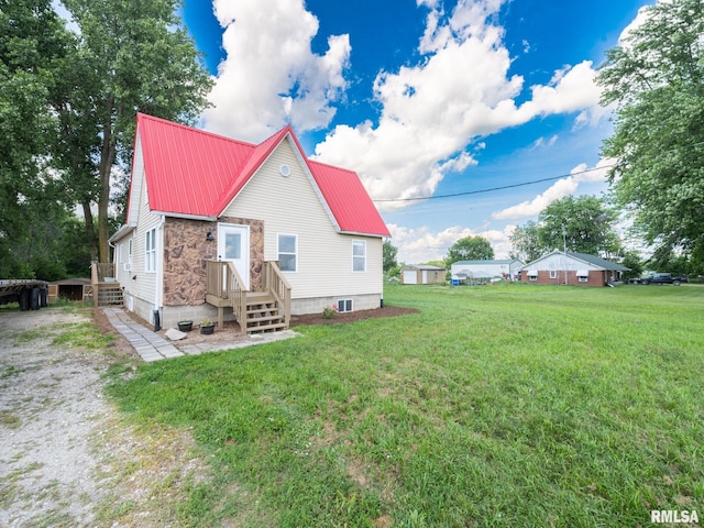 21218 E County Highway 17, Canton, IL 61520 - rear view of house featuring a yard, a metal roof, and stone siding