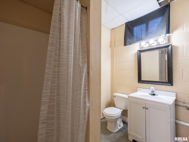 21218 E County Highway 17, Canton, IL 61520 - bathroom with concrete block wall, vanity, a paneled ceiling, and a shower with curtain