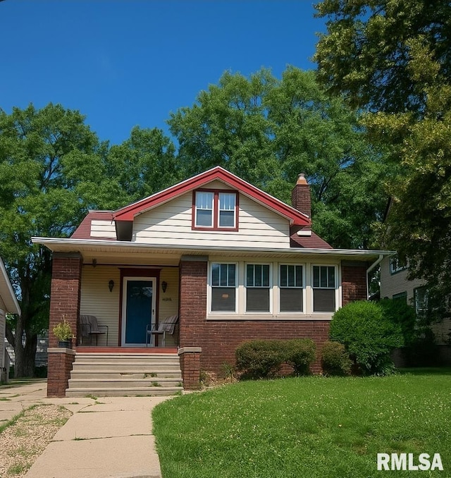 211 E Frye Ave, Peoria, IL 61603 - bungalow with covered porch, brick siding, a front yard, and a chimney