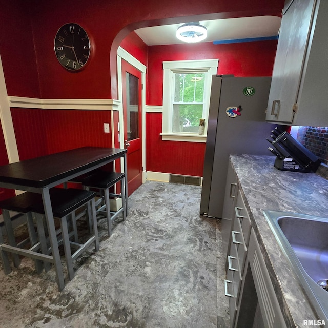 211 E Frye Ave, Peoria, IL 61603 - kitchen featuring arched walkways and freestanding refrigerator
