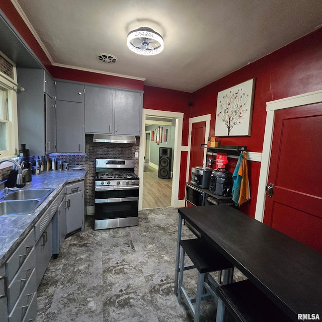 211 E Frye Ave, Peoria, IL 61603 - kitchen featuring gas range, under cabinet range hood, washer / clothes dryer, gray cabinets, and backsplash