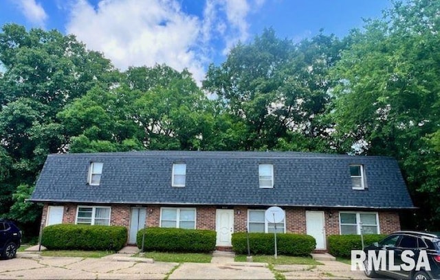3409-3415 W Richwoods Blvd, Peoria, IL 61604 - townhome / multi-family property with brick siding, roof with shingles, mansard roof, and view of scattered trees