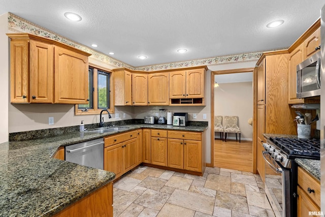 5408 N Rothmere Dr, Peoria, IL 61615 - kitchen with appliances with stainless steel finishes, a textured ceiling, recessed lighting, dark stone counters, and stone tile flooring
