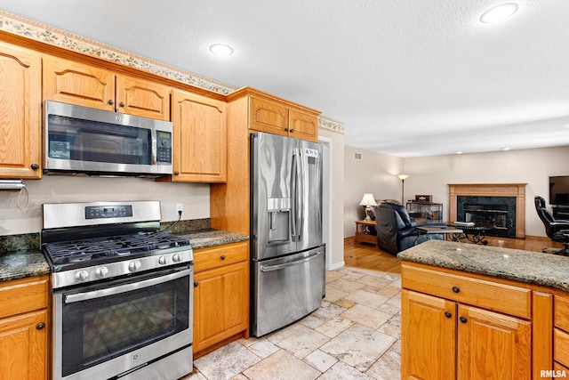 5408 N Rothmere Dr, Peoria, IL 61615 - kitchen featuring stainless steel appliances, a high end fireplace, stone tile flooring, a textured ceiling, and open floor plan