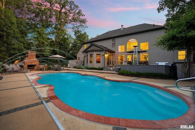 88 Waldheim Rd, Morton, IL 61550 - pool at dusk with a patio area and a stone fireplace