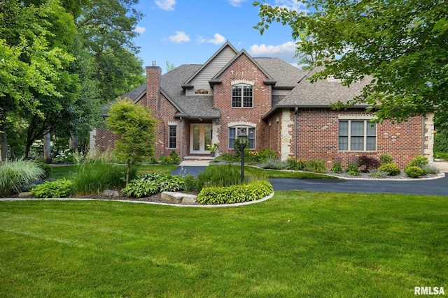 88 Waldheim Rd, Morton, IL 61550 - traditional-style home with a chimney, a shingled roof, french doors, a front lawn, and brick siding