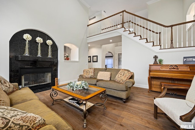 88 Waldheim Rd, Morton, IL 61550 - living room featuring wood finished floors, a tiled fireplace, stairs, crown molding, and a high ceiling