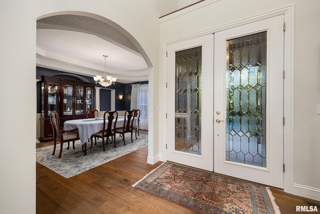 88 Waldheim Rd, Morton, IL 61550 - foyer entrance featuring a chandelier, wood finished floors, arched walkways, a raised ceiling, and french doors