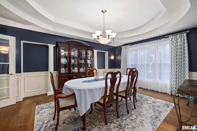 88 Waldheim Rd, Morton, IL 61550 - dining space featuring a chandelier, a raised ceiling, a wainscoted wall, wood finished floors, and a decorative wall