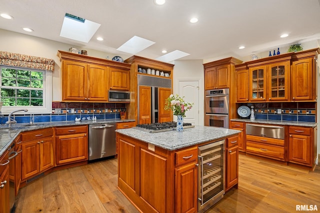 88 Waldheim Rd, Morton, IL 61550 - kitchen with beverage cooler, appliances with stainless steel finishes, a warming drawer, a skylight, and light wood-type flooring