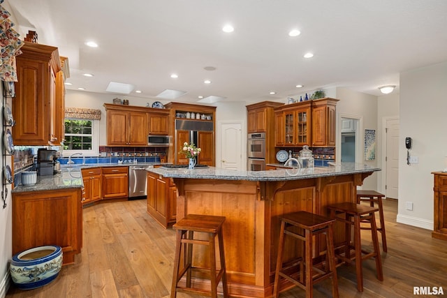 88 Waldheim Rd, Morton, IL 61550 - kitchen featuring stainless steel appliances, brown cabinetry, tasteful backsplash, a breakfast bar area, and recessed lighting