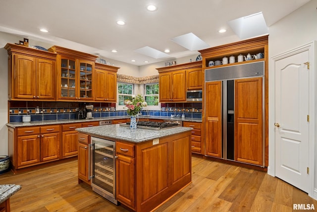 88 Waldheim Rd, Morton, IL 61550 - kitchen with beverage cooler, appliances with stainless steel finishes, a skylight, tasteful backsplash, and brown cabinets