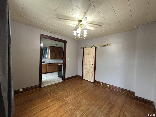1208 S 13th St, Pekin, IL 61554 - unfurnished room featuring a barn door, light wood-type flooring, and a ceiling fan