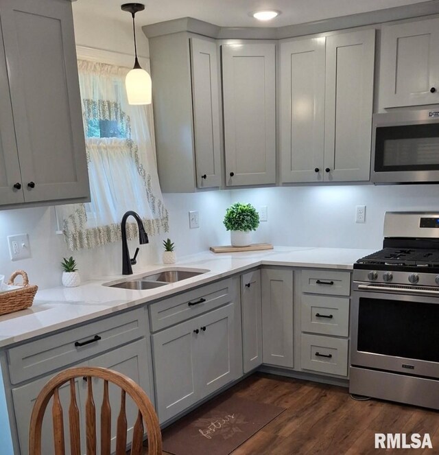 751 N 3rd St, Cuba, IL 61427 - kitchen featuring appliances with stainless steel finishes, dark wood-style flooring, pendant lighting, light stone counters, and gray cabinets