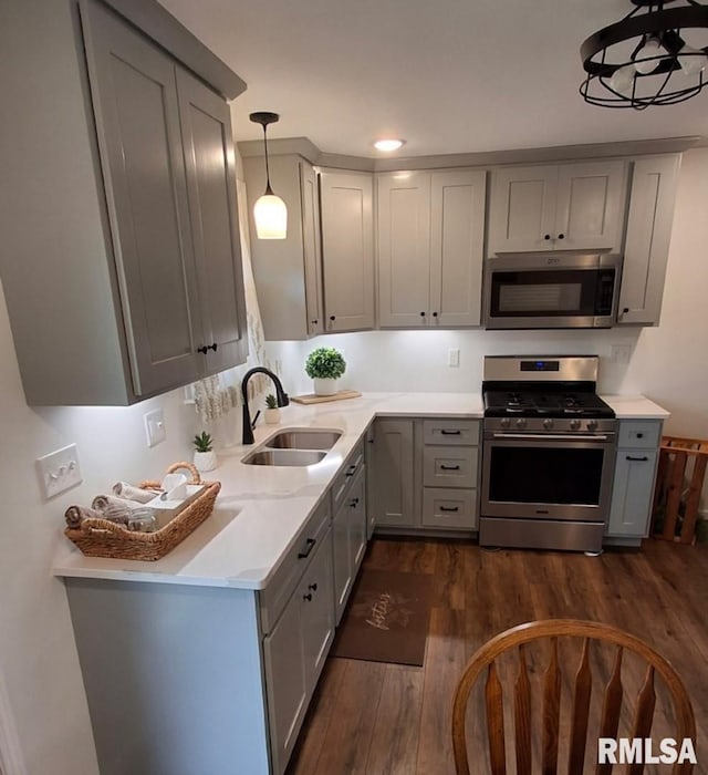 751 N 3rd St, Cuba, IL 61427 - kitchen featuring appliances with stainless steel finishes, gray cabinets, dark wood-style floors, and hanging light fixtures