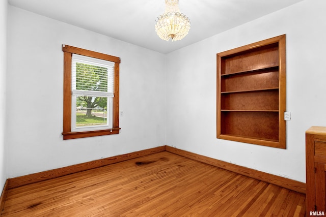 1603 Willow St, Pekin, IL 61554 - empty room featuring wood finished floors and a chandelier