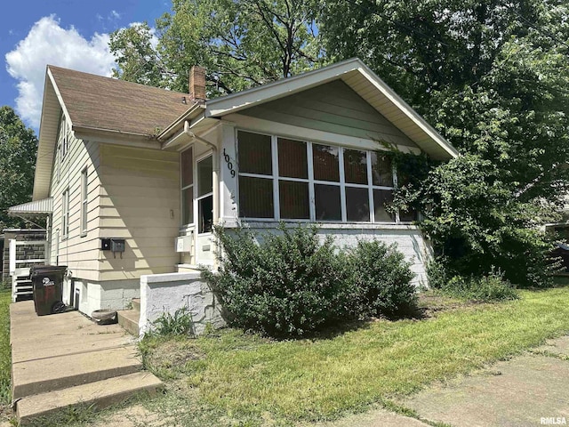 1009 W Armstrong Ave, Peoria, IL 61606 - view of front of property with a chimney, a front yard, and a shingled roof