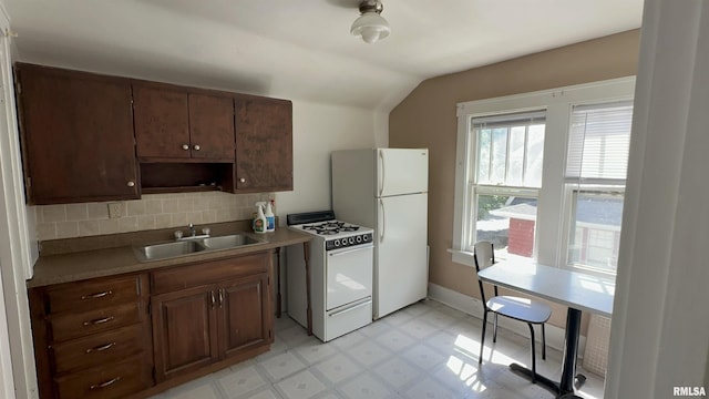 1009 W Armstrong Ave, Peoria, IL 61606 - kitchen featuring white appliances, lofted ceiling, light floors, tasteful backsplash, and light countertops