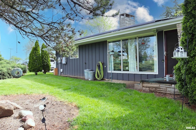 201 Willa Ln, Washington, IL 61571 - view of property exterior featuring a chimney, board and batten siding, and a yard