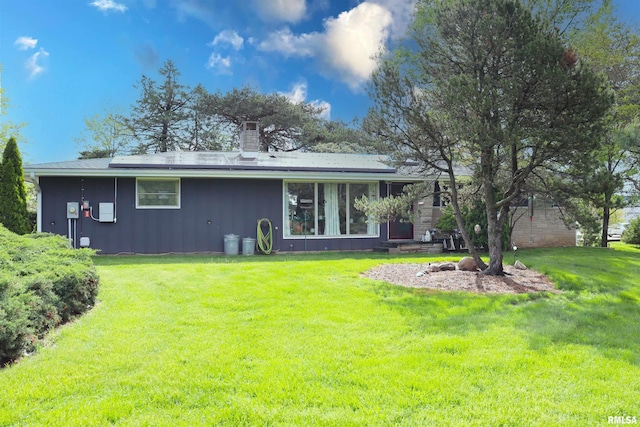 201 Willa Ln, Washington, IL 61571 - rear view of property featuring board and batten siding, solar panels, a chimney, and a yard