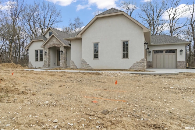 6604 W Stonebrook Dr, Edwards, IL 61528 - view of front of property featuring stucco siding, stone siding, a garage, and a shingled roof