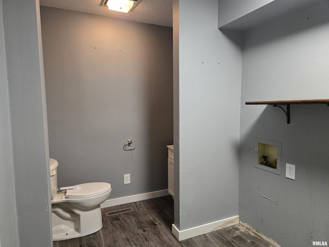 102 Conch Dr, La Harpe, IL 61450 - washroom featuring dark wood-type flooring, hookup for a washing machine, and a textured ceiling