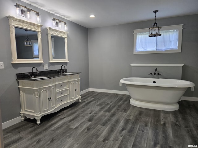 102 Conch Dr, La Harpe, IL 61450 - bathroom with double vanity, a freestanding bath, wood finished floors, and recessed lighting