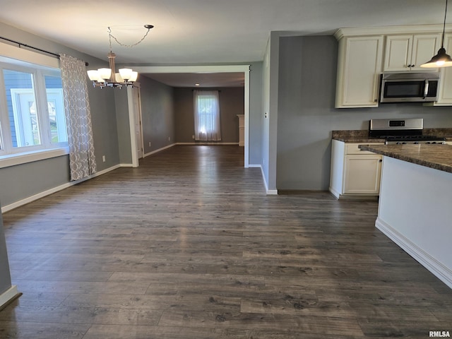 102 Conch Dr, La Harpe, IL 61450 - kitchen with stainless steel appliances, a chandelier, open floor plan, dark wood-style floors, and decorative light fixtures