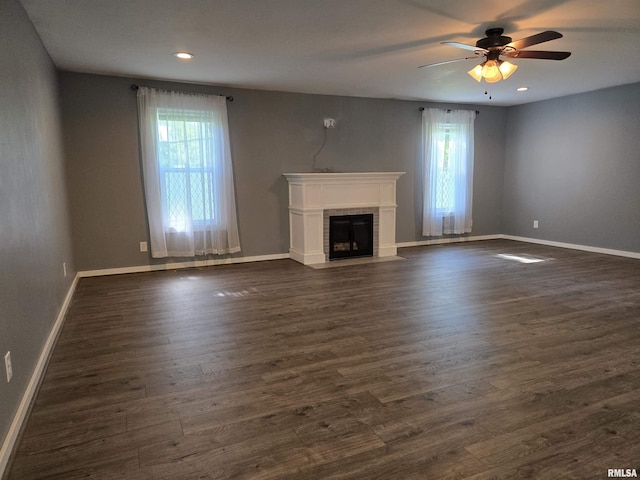 102 Conch Dr, La Harpe, IL 61450 - unfurnished living room featuring healthy amount of natural light, a ceiling fan, a fireplace with flush hearth, dark wood finished floors, and recessed lighting