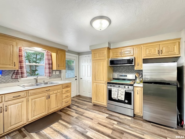 1506 S Capitol St, Pekin, IL 61554 - kitchen with appliances with stainless steel finishes, tasteful backsplash, light countertops, light brown cabinets, and a textured ceiling