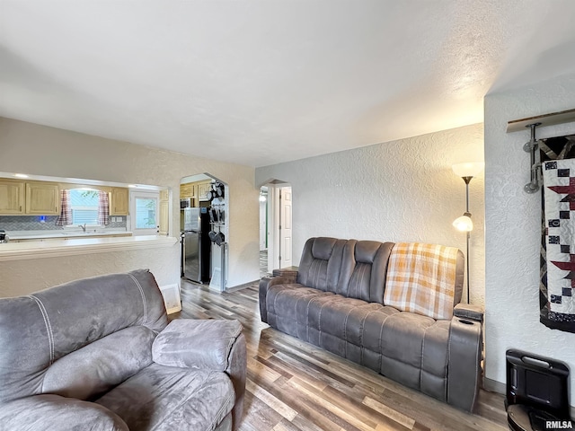 1506 S Capitol St, Pekin, IL 61554 - living area featuring a textured wall, arched walkways, and light wood-style flooring