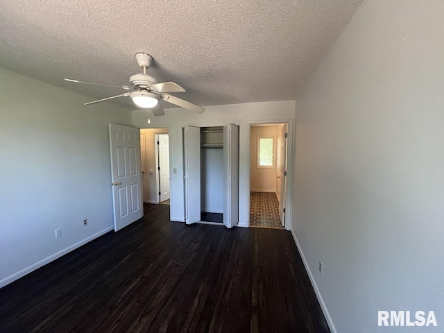 15 Cedar Dr, Macomb, IL 61455 - unfurnished bedroom with dark wood finished floors, a textured ceiling, a closet, and ceiling fan