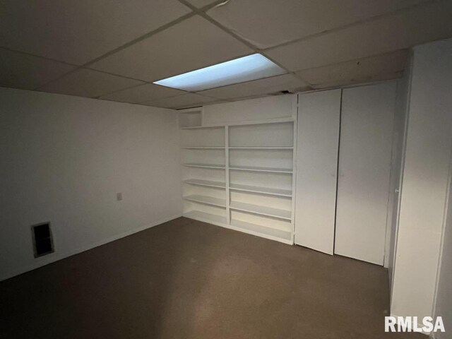 15 Cedar Dr, Macomb, IL 61455 - finished basement with a drop ceiling, built in shelves, and dark colored carpet