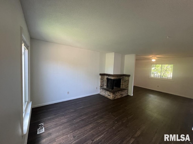 15 Cedar Dr, Macomb, IL 61455 - unfurnished living room with dark wood finished floors, a fireplace, a textured ceiling, and ceiling fan