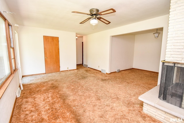 1602 Highwood Ave, Pekin, IL 61554 - unfurnished living room featuring ceiling fan, carpet flooring, a fireplace, and plenty of natural light